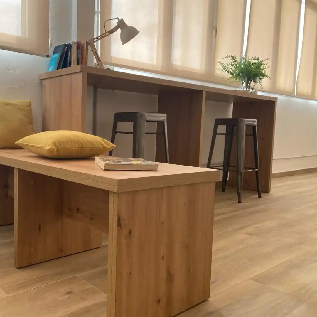 Espacio de trabajo en el Coworking Rivus, con mesa de trabajo, sillas altas y una decoración minimalista.