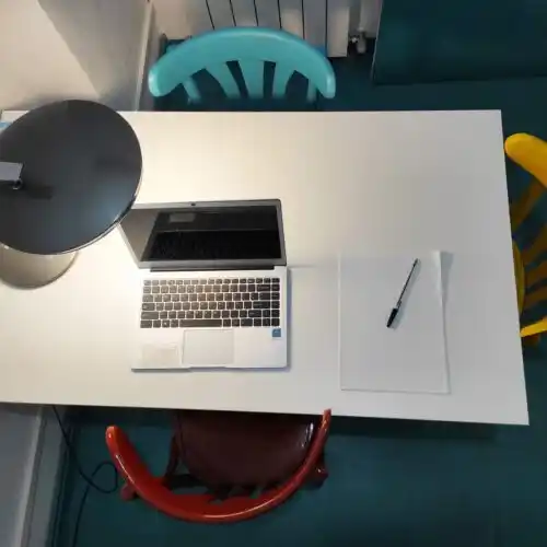 Espacio de trabajo en el Centro 'Tu lugar de trabajo', con mesa blanca y sillas coloridas