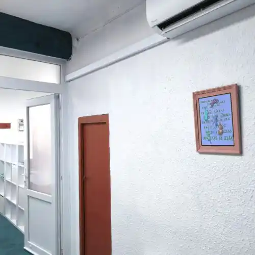 Pared del Centro 'Tu lugar de trabajo', mostrando una unidad de aire acondicionado y decoración sencilla.