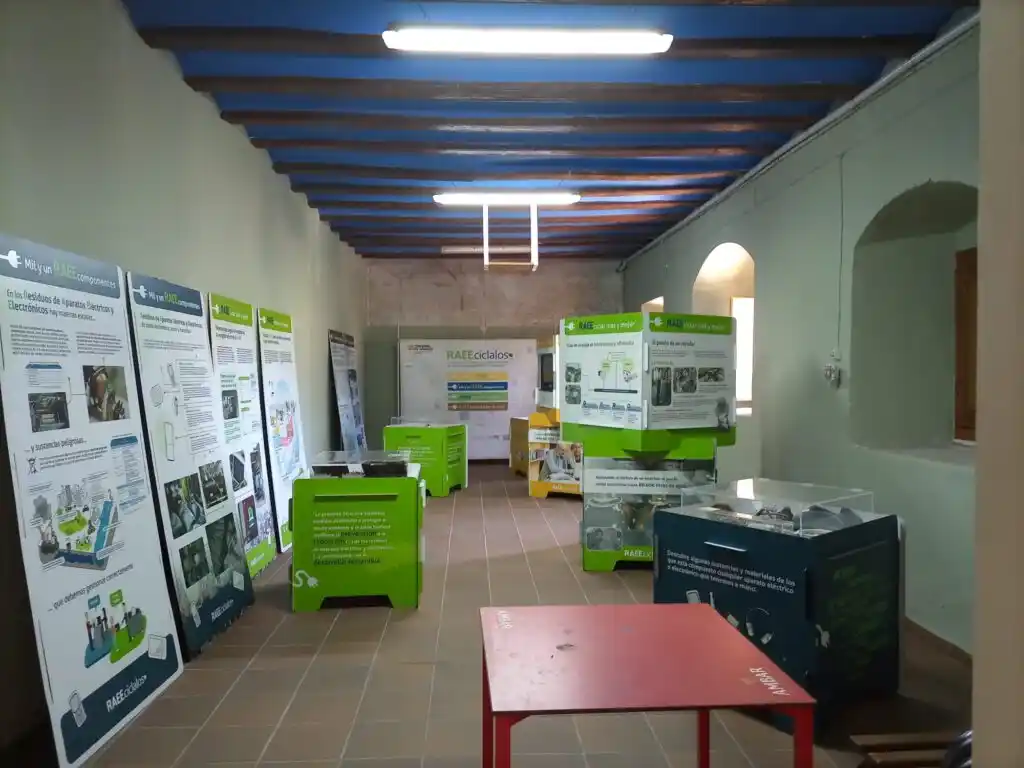 Sala de exposición en el Convento de la Consolación de Gotor con paneles informativos sobre reciclaje y desechos electrónicos.