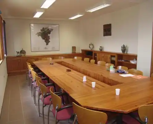 Sala de reuniones en el Centro Maestrazgo, con una mesa grande de madera y sillas alrededor.