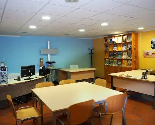 Oficina del Centro Emprendedores Canfranc, con mesas y estanterías llenas de libros.