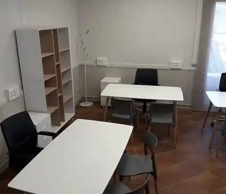 Oficina compartida en el centro de Boltaña con mesas de trabajo y sillas.