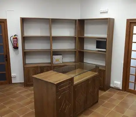 Biblioteca o área de almacenamiento en el centro de Boltaña, con estanterías de madera.