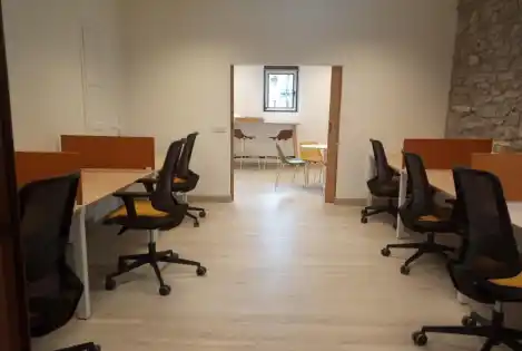 Oficina compartida con escritorios y sillas cómodas en Broto.