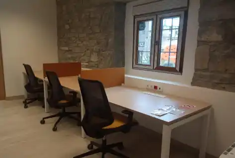 "Oficina con escritorios y ventana exterior en Broto.