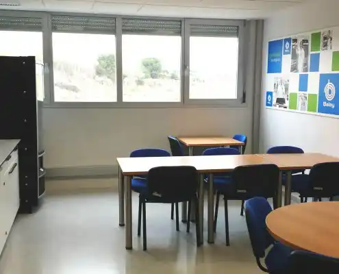 Sala común en el CEMINEM Zaragoza con mesas y sillas azules.