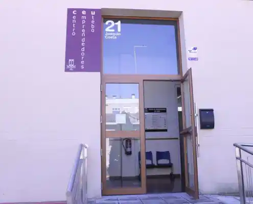 Entrada al Centro de Emprendedores de Utebo, con puerta de cristal y un letrero visible.