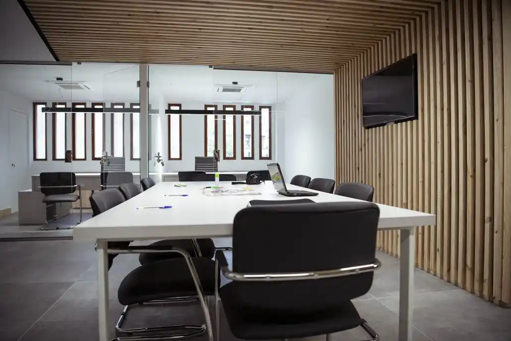 Sala de reuniones moderna en el Centro Alcorisa con mesa, sillas y paredes de madera.