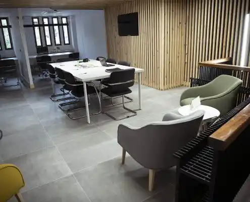 Sala de reuniones moderna en el Centro Alcorisa con mesa, sillas y paredes de madera.