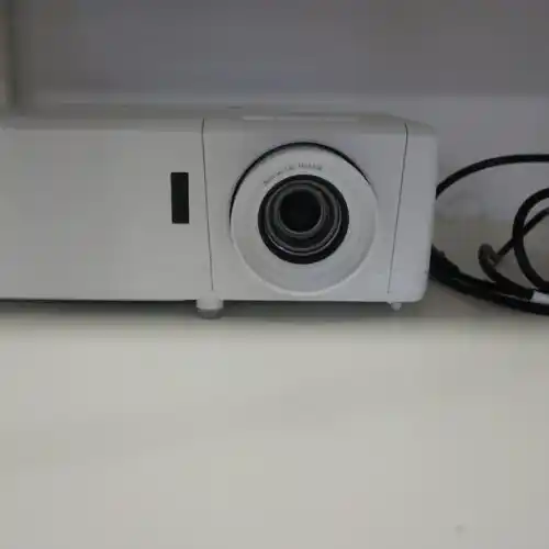 Proyector blanco con lente visible.