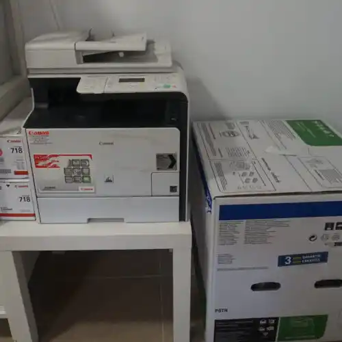 Impresora multifunción Canon con cajas de papel.