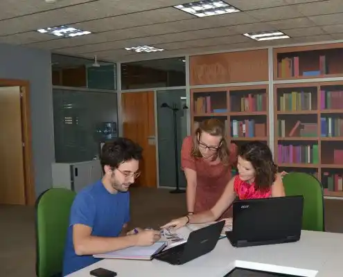 Tres personas trabajando juntas en Cowalking Huesca en un espacio compartido.