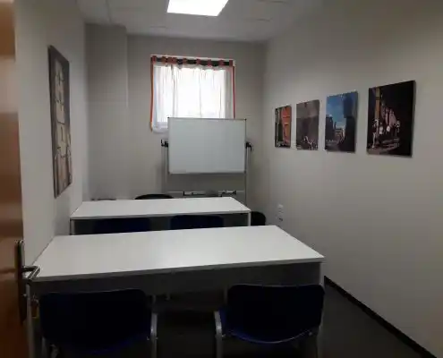 Sala de reuniones en el Centro Alcañiz con mesa, sillas y decoración en las paredes.