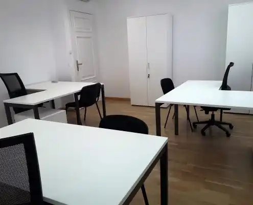 Oficina con mesas y sillas negras en un ambiente moderno