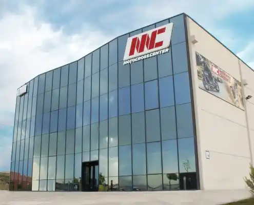 Fachada del Motocross Center en Technopark, con amplias ventanas y el logo de la marca en el edificio.