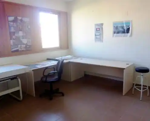 Despacho en el Centro Maestrazgo, con mesas de trabajo sencillas y una silla ergonómica.