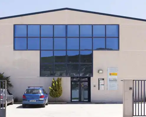 Fachada exterior del Centro Andorra con ventanales grandes y coches estacionados.