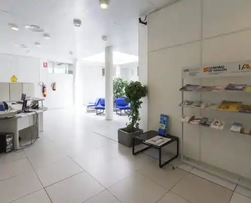 Área de recepción con mesas y sillas azules en el CEEI Teruel.