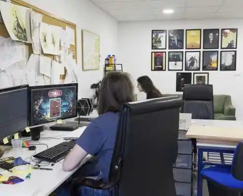 Oficina con escritorios, computadoras y posters en las paredes en el CEEI Teruel.
