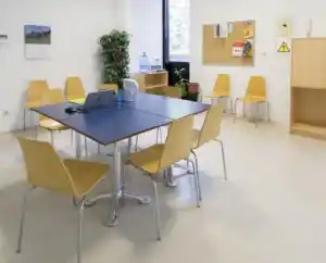 Sala de trabajo en el Centro Huesca, con mesa de trabajo y sillas amarillas, brindando un ambiente cómodo para emprendedores.
