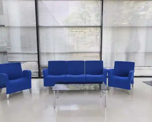 Área de descanso con sillones azules y mesa en el Centro Huesca.