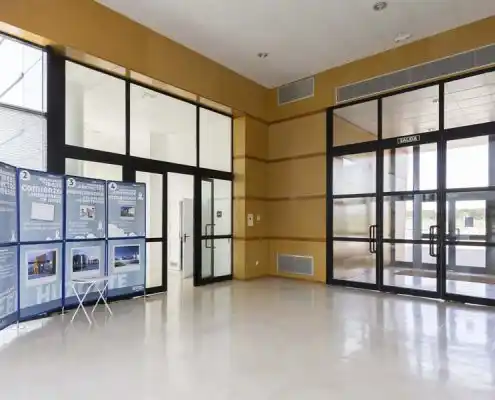 Entrada del Centro Huesca con panel informativo y puertas de cristal.