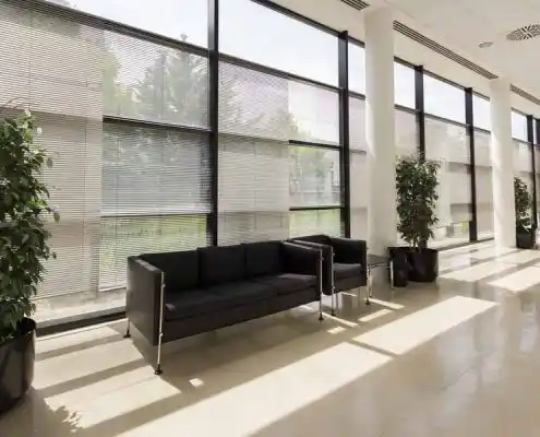 Sala de espera con sofás negros y luz natural en el Centro Huesca.