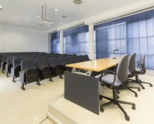 Aula de conferencias con sillas y mesa en el Centro Huesca.