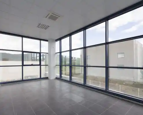Oficina en el centro Graus con amplios ventanales y vista exterior.