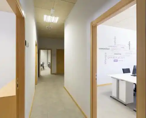 Pasillo con paredes blancas y puertas amarillas en el Centro Barbastro.