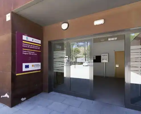 Entrada principal al Centro Barbastro con puerta de cristal y letrero.