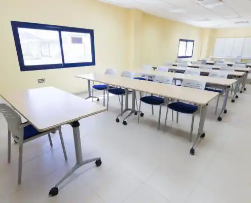 Aula amplia en el Centro Andorra con mesas dispuestas para clases y buena iluminación natural.