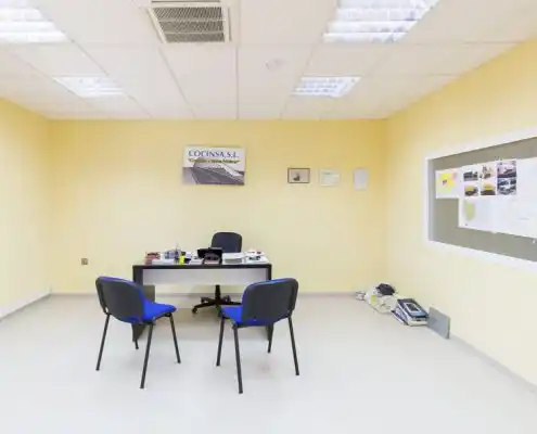 Oficina en el Centro Andorra con escritorio vacío, documentos y decoración mínima.