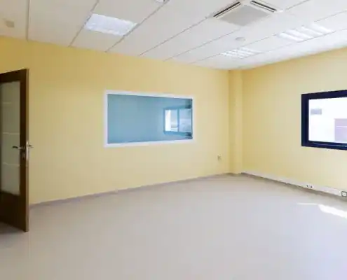 Oficina sin muebles en el Centro Andorra con paredes amarillas y ventana.