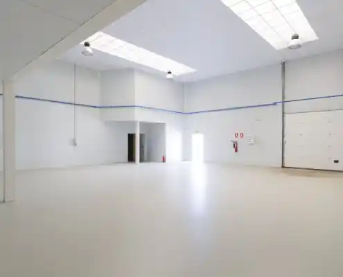 Espacio interior en el Centro Andorra con extintores y salida visible.