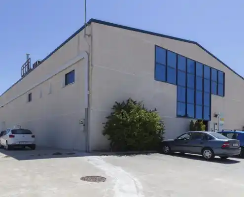 Fachada lateral del Centro Andorra con ventanales y coches estacionados.