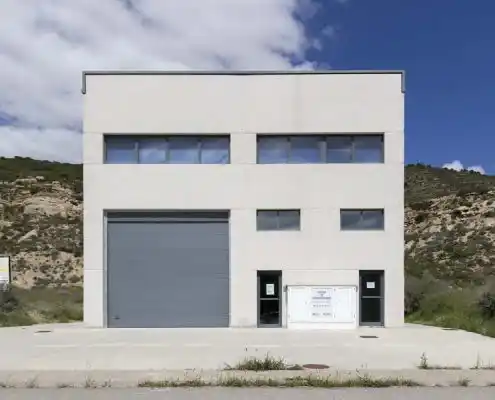 Fachada exterior del centro Mequinenza con acceso para vehículos y entradas.