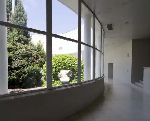 Pasillo del CEEI Teruel con grandes ventanales y vista al jardín.