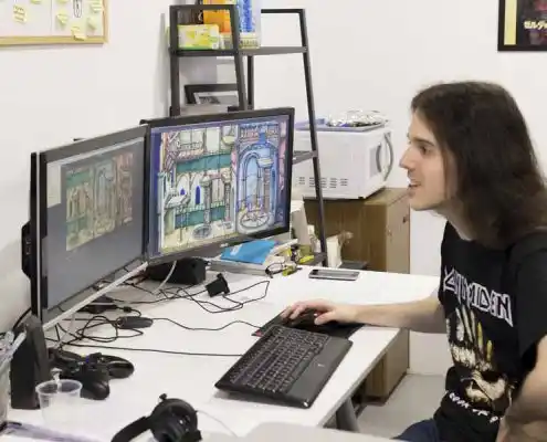 Diseñador trabajando en el CEEI Teruel, editando gráficos en su computadora.