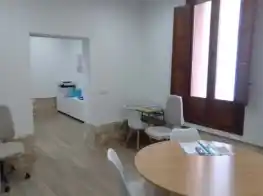 Espacio con mesa redonda y sillas en el Centro Mas de las Matas, mostrando una zona de trabajo compartida.