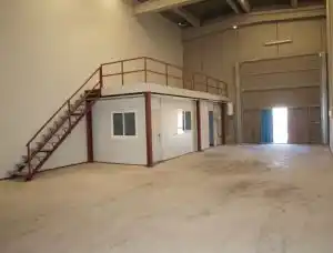 Interior de la nave del CEEI, mostrando el espacio abierto con un mezzanine y una estructura metálica.