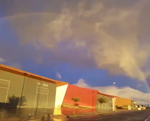 Vista exterior de las naves industriales en Technopark, mostrando fachadas de diferentes colores bajo un cielo parcialmente nublado
