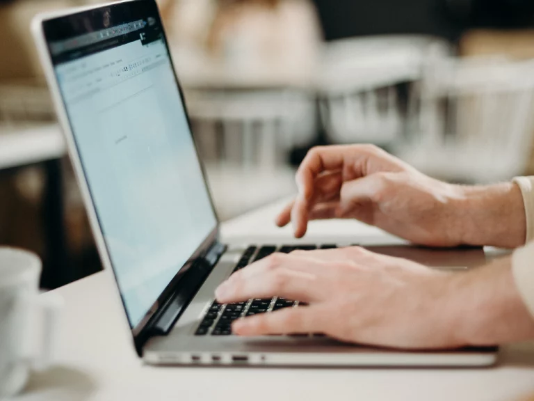 Persona escribiendo en un laptop en el coworking de Longas
