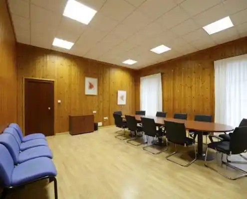 Sala de reuniones en el Centro Sabiñánigo, con mesa grande, sillas y ambiente profesional.