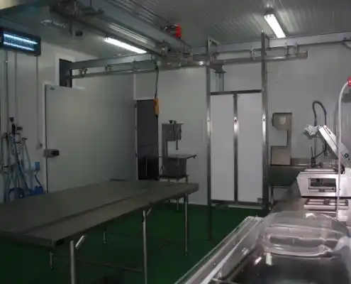 Espacio de trabajo en el Centro Vivero de Jaca, con mesas y artefactos de acero inoxidable, creando un ambiente profesional y moderno.