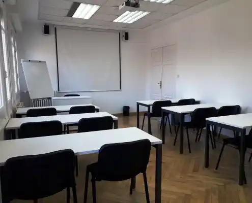 Sala de formación equipada con sillas y mesas para clases.