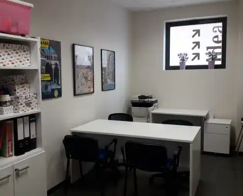 Oficina moderna en el Centro Alcañiz con escritorios, sillas y decoración en las paredes.