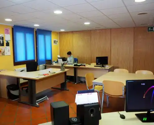 Oficina en el Centro Emprendedores Canfranc, con un trabajador en su escritorio y mobiliario de oficina.