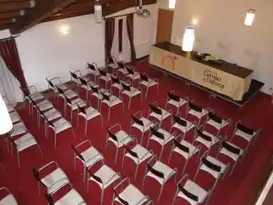 ala de conferencias en la Fundación Campo da Roca, con sillas organizadas y una mesa con el logo de la institución en el fondo